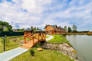 a bridge over a river in front of a house at Zarichna in Drogobych