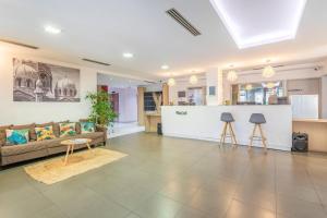 a large living room with a couch and a kitchen at Comfort Aparthotel Marseille Prado in Marseille