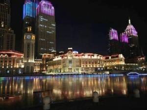 miasto oświetlone nocą rzeką i budynkami w obiekcie 7 Days Inn Tianjin Railway Station w mieście Tiencin