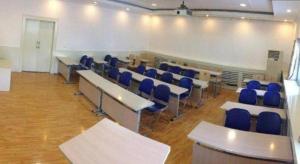 Un aula con escritorios y sillas azules en una habitación. en 7 Days Inn Hohhot Hailiang Xinhua Square Metro Station, en Hohhot