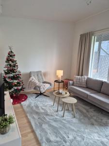 a living room with a christmas tree and a couch at Arctic Circle Cozy Nest in Rovaniemi
