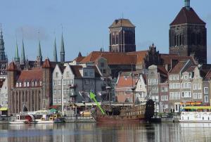 eine Stadt mit Gebäuden und einem Fluss mit Booten in der Unterkunft Gdansk Old Town River View in Danzig