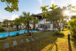 a house with a swimming pool and palm trees at Lanna Fusion in Hang Dong