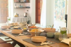 a table with bowls of food on top of it at Lotus Surf And Wellness in Ahangama