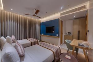 a hotel room with two beds and a table at Ira by Orchid Dwarka in Dwarka +32 photos
