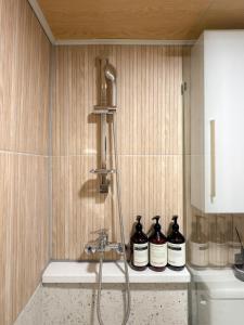 Una ducha en un baño con tres botellas en un mostrador. en 스테이프랑, en Seúl