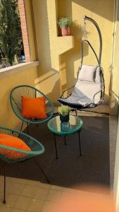een veranda met een schommel, 2 stoelen en een tafel bij La casa di Mery Sun in Milaan +6 foto's