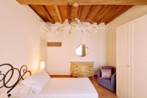 una camera da letto con un letto bianco e un lampadario di Casa Lippa a Spilamberto Altre 30 foto