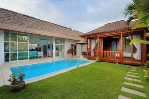 a house with a swimming pool and a yard at Villa Blue Pearl by Optimum Bali Villas in Seminyak