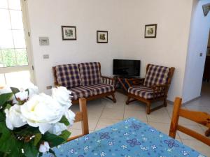 a living room with two chairs and a television at Villa Casanova in Santa Margherita di Pula