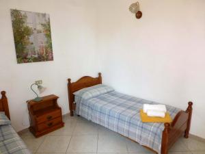 a small bedroom with two beds and a nightstand at Villa Casanova in Santa Margherita di Pula
