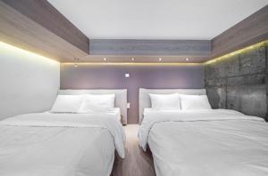 a bedroom with two beds with white sheets at 구로 서울 인 호텔 in Seoul