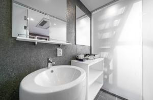 a white bathroom with a sink and a mirror at 구로 서울 인 호텔 in Seoul