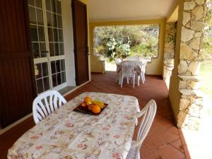 a table with a plate of fruit on a patio at Villa Casanova in Santa Margherita di Pula