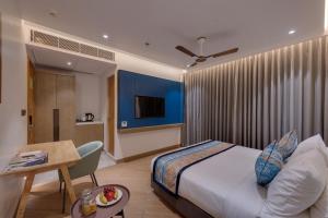 a hotel room with a bed and a table and a tableablish at Ira by Orchid Dwarka in Dwarka