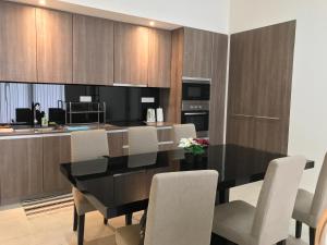 a dining room with a black table and white chairs at By The Sea Cozy Beachfront Home 253 in Batu Ferringhi