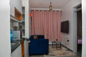 a living room with a blue chair and a table at Tsavo Stanley kiambu Road in Gatunga