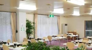 a room with tables and chairs in a room at Kinugawa Niouson Plaza Hotel in Nikko