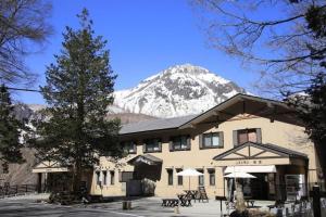 a building with a snow covered mountain in the background at Kamikochi Taishoike Hotel in Matsumoto