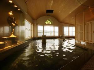 a large indoor swimming pool in a building with water at Hotel Matsumotoro in Shibukawa