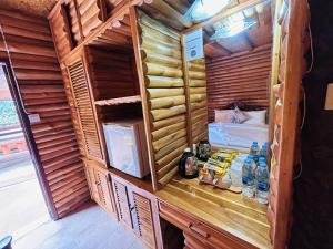 a wooden cabin with a bed in a room at ศศิคันทรี รีสอร์ท in Suan Phung