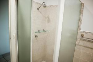 a shower with a glass door in a bathroom at Double room with shared bathoom in Auburn