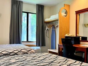 a hotel room with a bed and a desk with a computer at Rodeway Inn Boise Airport in Boise