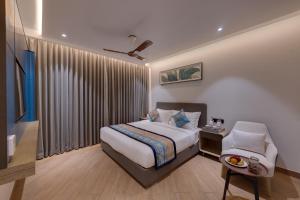 a hotel room with a bed and a chair at Ira by Orchid Dwarka in Dwarka