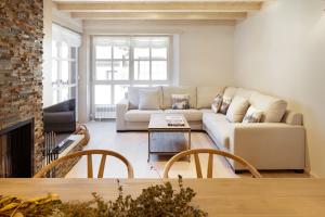 Val de Ruda Luxe 41 by FeelFree Rentals في باكويرا بيريت: غرفة معيشة مع أريكة ومدفأة