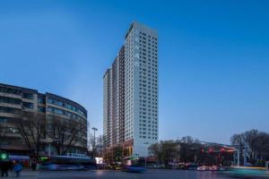 a tall building on a city street with at Xana Hotelle·Xining Dashizi Central Square in Xining