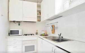 a white kitchen with white cabinets and a sink at San Rocco Apartment in Venice