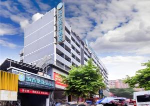 a large building on a city street with cars at City Comfort Inn Hotel Guiyang Normal University Yangmingci Metro Station in Guiyang