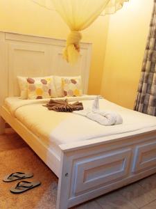 ein Bett mit zwei weißen Handtüchern darauf in der Unterkunft Villa serene hotel kitale in Kitale