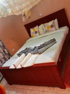 ein Bett mit einem Holzrahmen mit Handtüchern darauf in der Unterkunft Villa serene hotel kitale in Kitale