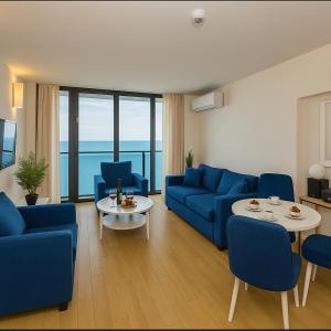 a living room with blue couches and a table at Orbi city new Tower in Batumi