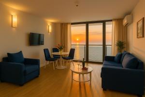 a living room with two blue chairs and a table at Orbi city new Tower in Batumi