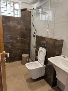 a bathroom with a toilet and a sink at Suvarna Millennium Suits in Mysore