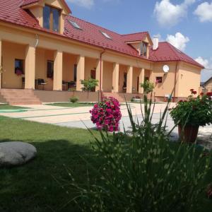 ein Gebäude mit rosa Blumen vor einem Hof in der Unterkunft Vila Mária Rapovce in Rapovce