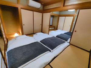 a room with three beds in it with mirrors at Solvana FUJIKAWAGUCHIKO in Fujikawaguchiko