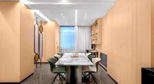 a dining room with a table and green chairs at GreenTree Inn Harbin Central Avenue in Harbin