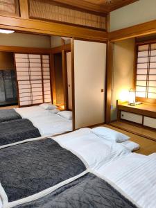 a group of four beds in a room with windows at Solvana FUJIKAWAGUCHIKO in Fujikawaguchiko