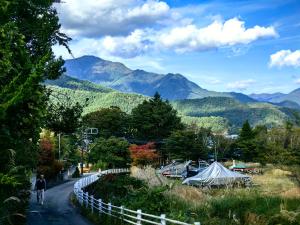 a person walking down a road with mountains in the background at Solvana FUJIKAWAGUCHIKO in Fujikawaguchiko