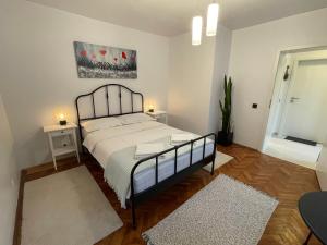 a bedroom with a large bed and two rugs at Your Home in Zărneşti +16 photos