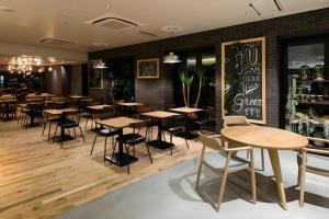 Un restaurante con mesas y sillas en una sala. en Hotel Edit Yokohama, en Yokohama