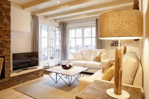 sala de estar con sofá blanco y TV en Val de Ruda Luxe 42 by FeelFree Rentals, en Baqueira Beret