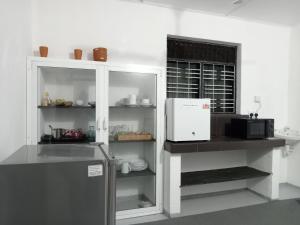 a kitchen with a refrigerator and a microwave at Bee Cottage Negombo in Negombo