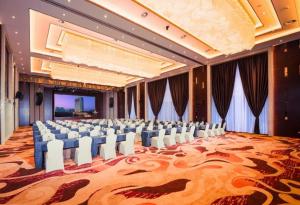 a large banquet hall with white chairs and a stage at New Century Grand Hotel Xi'an Xizang Building in Xi'an +239 photos