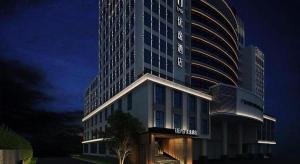 a large building with a hotel at night at Ueasy Hotel The Mixc in Nanning
