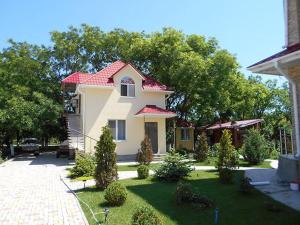 a small house with a red roof in a yard at Mini-Dacha in Kurortne