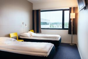 a hotel room with two beds and a window at Stavanger St Svithun Vandrerhjem in Stavanger